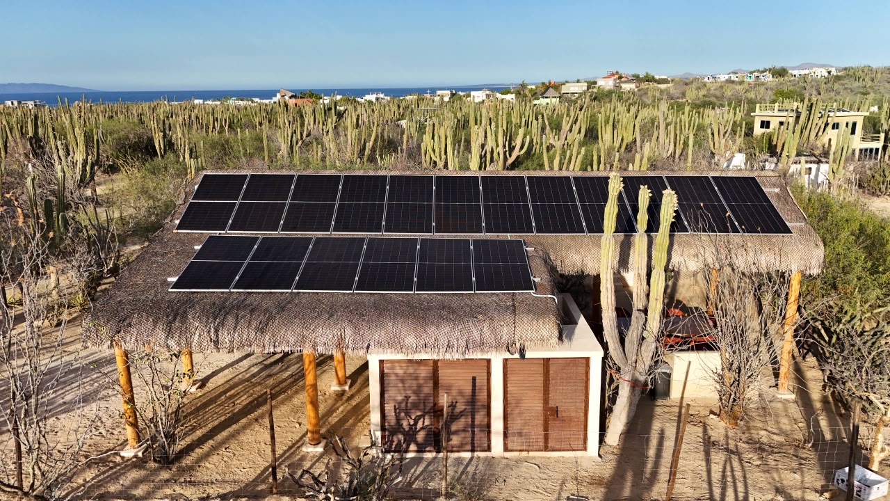 Vista frontal de la palapa y su arreglo solar con el mar al fondo